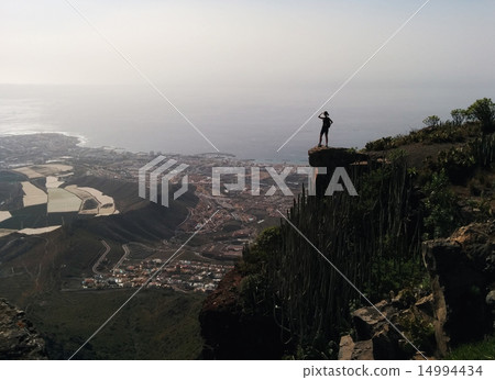 Woman on a edge of a mountain enjoying valley view 14994434