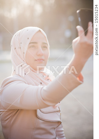 young beautiful muslim woman at the park young beautiful muslim woman at the park 15015234