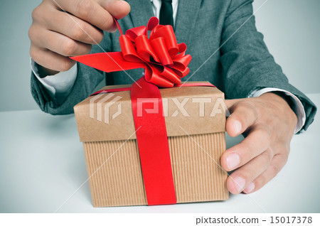 man in suit opening a gift 15017378