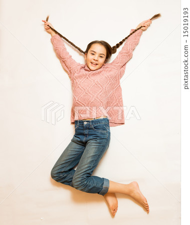 Isolated shot of happy girl with long braids jumping up high 15019193