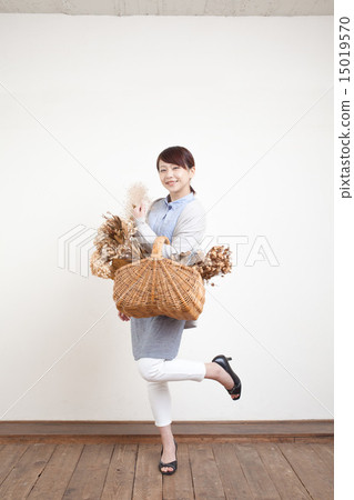 A woman holding a flower basket A woman holding a flower basket 15019570