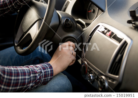 Closeup of man inserting key in car ignition lock Closeup of man inserting key in car ignition lock 15019951