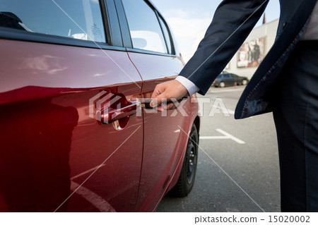 Closeup of businessman pulling car door handle 15020002