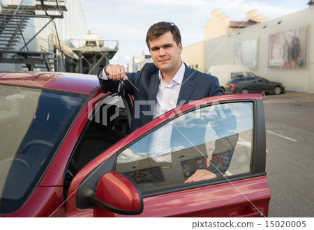 happy man posing with new car and showing keys 15020005