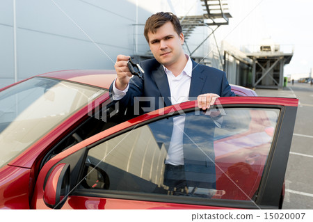 Portrait of happy businessman posing at car with keys 15020007
