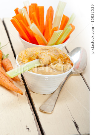 fresh hummus dip with raw carrot and celery 15022539