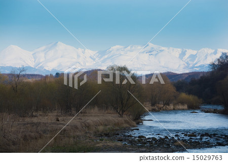 Snow melting river and snowy mountains Snow melting river and snowy mountains 15029763