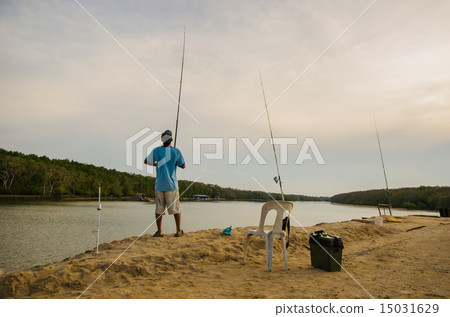 Man fishing in front of river at evening Man fishing in front of river at evening 15031629