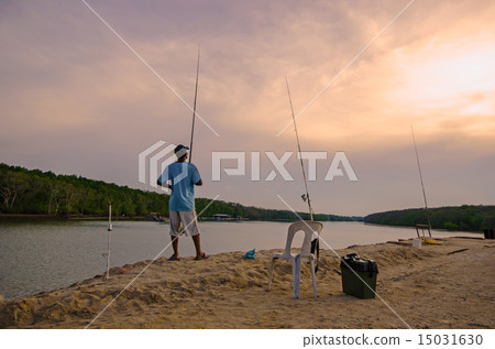 Man fishing in front of river at evening Man fishing in front of river at evening 15031630