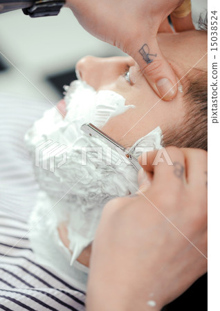 Client shaving at barber shop 15038524