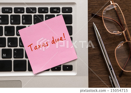 Notepad with word " Taxes due " putting on laptop 15054715