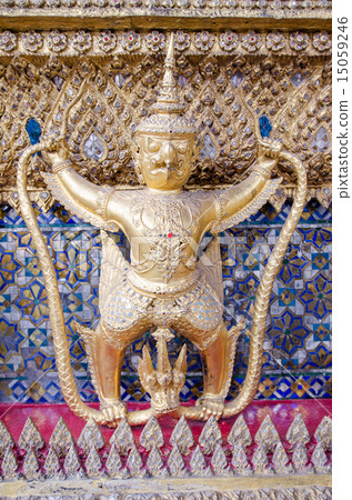 A Golden Garuda stands alone in front of a wall 15059246