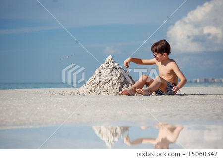 Cute little son building sand castle at beach 15060342