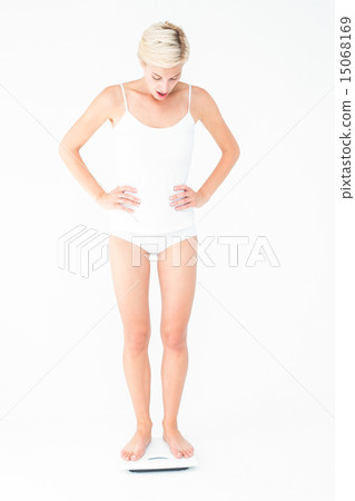 Blonde woman standing on weighing scales 15068169