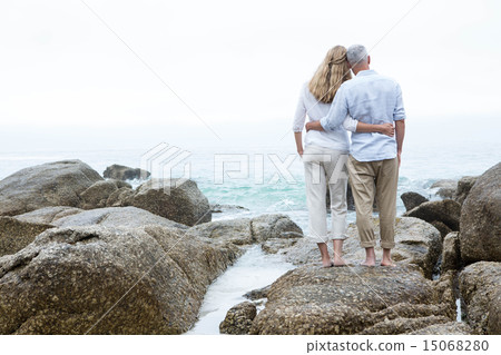 Happy couple standing on the rock and looking at the sea 15068280