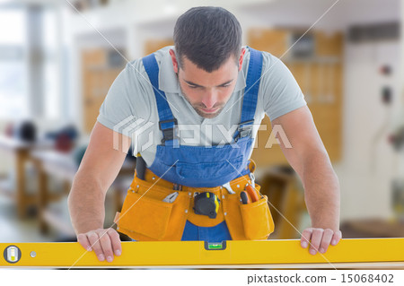 Composite image of worker using spirit level 15068402
