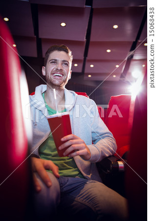 Happy young man watching a film Happy young man watching a film 15068438