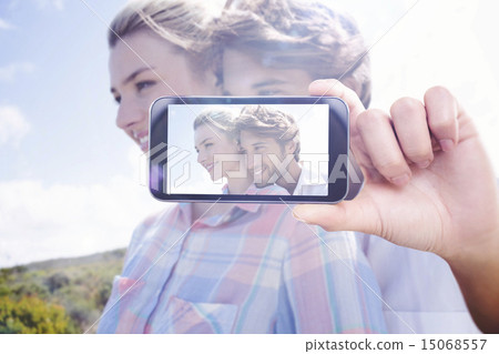 Composite image of hand holding smartphone showing 15068557