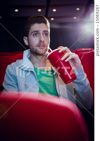 Young man watching a film Young man watching a film 15069267