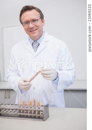Happy scientist holding kernel in tube 15069520