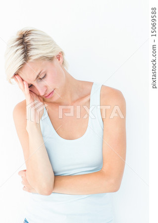 Depressed blonde woman with hand on temple 15069588
