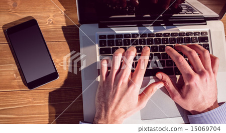 Businessman using laptop at desk 15069704