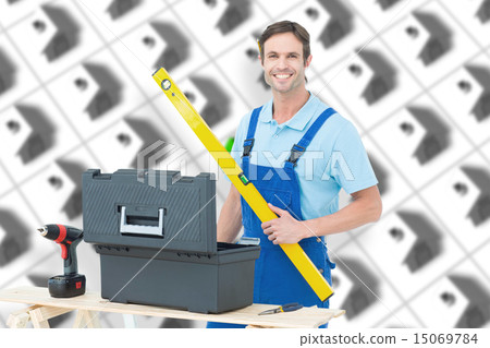 Composite image of carpenter holding spirit level at table Composite image of carpenter holding spirit level at table 15069784