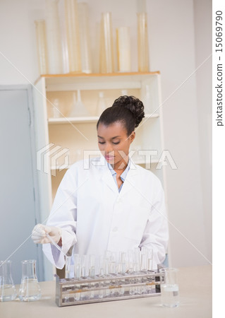 Concentrated scientist working attentively with pipette 15069790