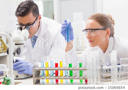 Focused scientists examining test tube Focused scientists examining test tube 15069854