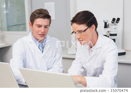 Scientists working attentively with laptop 15070474