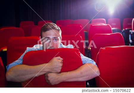 Young man watching a scary film Young man watching a scary film 15070622