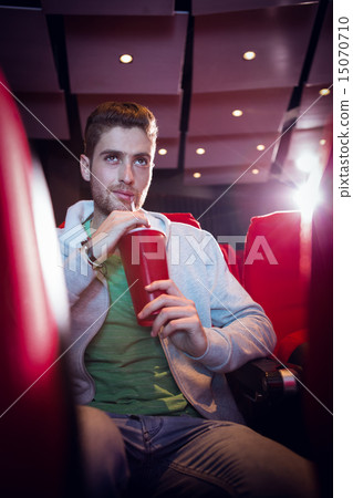Happy young man watching a film Happy young man watching a film 15070710
