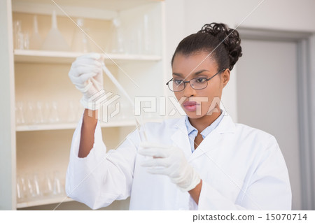 Concentrated scientist working attentively with pipette 15070714