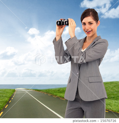 Composite image of businesswoman posing with binoculars 15070716
