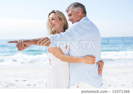 Happy couple hugging each other and pointing something 15071366