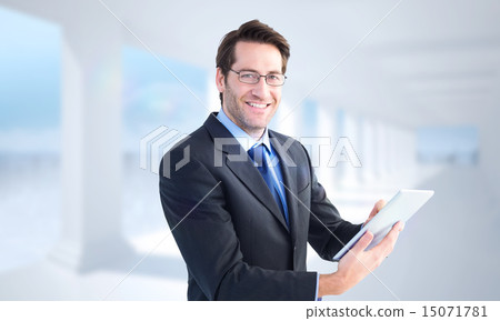 Composite image of businessman looking at the camera while using 15071781