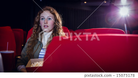 Young woman watching a film Young woman watching a film 15073178