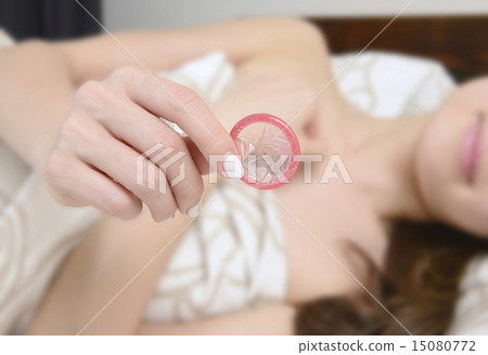 A hand of a young woman with a condom 15080772