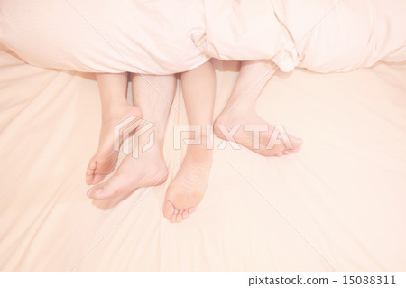Couple feet coming out of futon 15088311