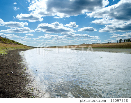 green grass with river under cloudy sky 15097558