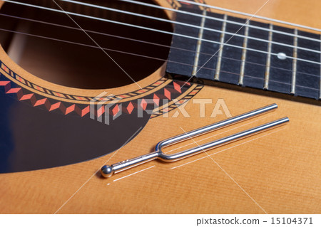 Music tuning fork on acoustic guitar strings 15104371