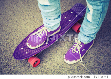 Young skateboarder in gumshoes and jeans 15110951