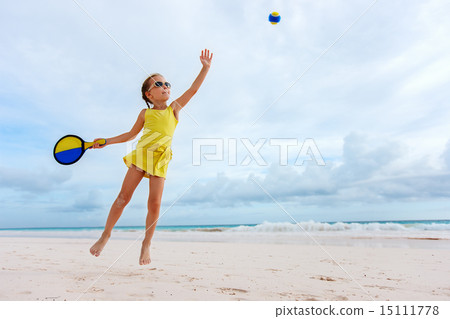 Little girl playing beach tennis Little girl playing beach tennis 15111778