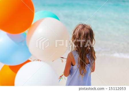 Back view of little girl with balloons at beach Back view of little girl with balloons at beach 15112053