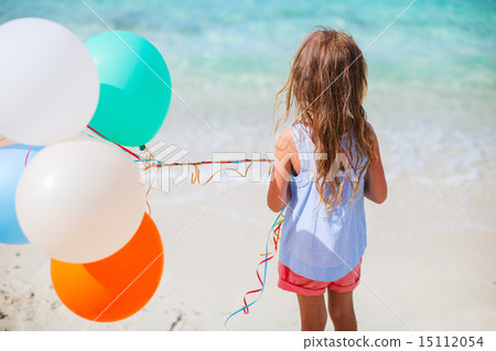 Back view of little girl with balloons at beach Back view of little girl with balloons at beach 15112054