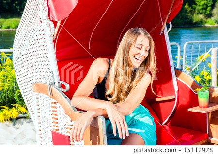 Woman in wicker bench chair 15112978
