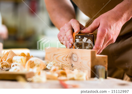 Carpenter with sanding block in carpentry 15112997