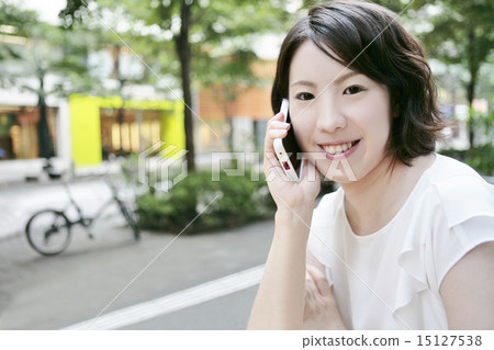 A woman who makes a mobile phone with a smile A woman who makes a mobile phone with a smile 15127538