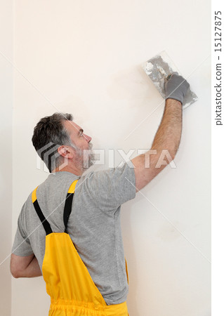 Worker repairing plaster at wall 15127875