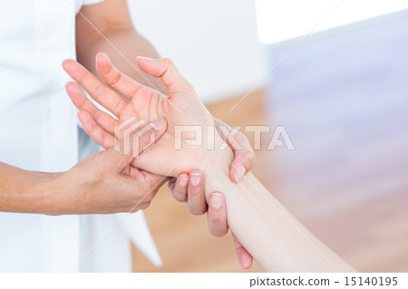 Physiotherapist massaging her patients hand Physiotherapist massaging her patients hand 15140195